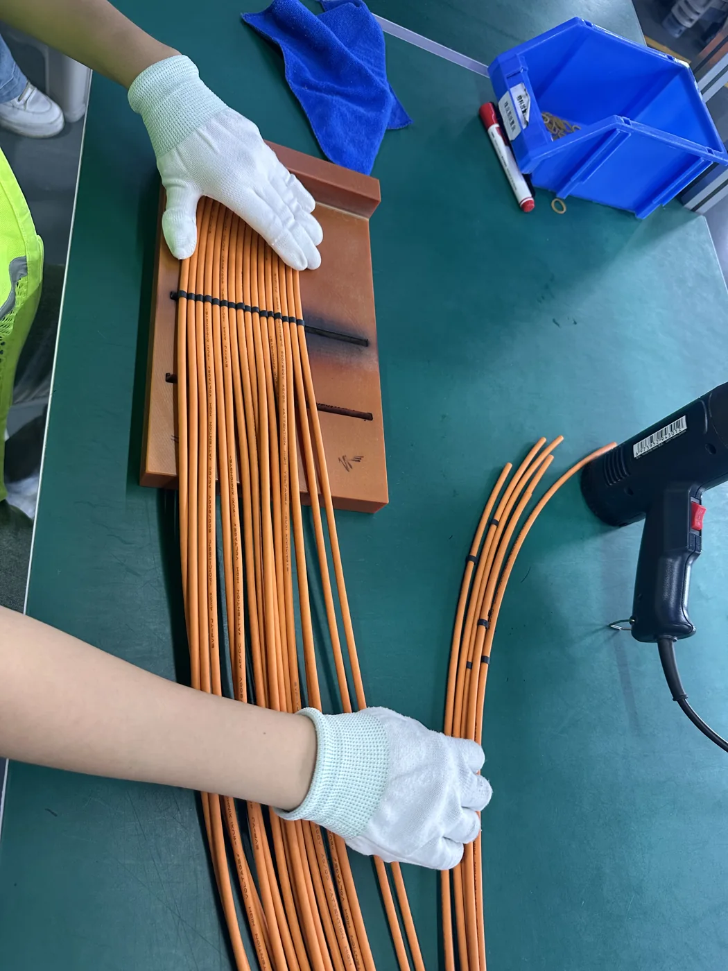 Operator checking aligned high-voltage cables during production